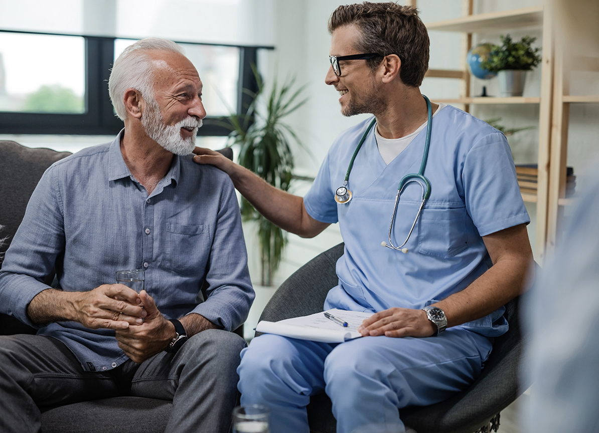 Smiling doctor with his right hand on old man left shoulder