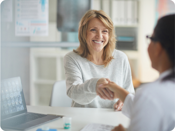 Smiling woman shaking hands with a female doctor